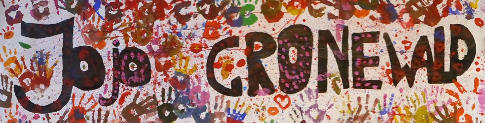 Der abgekürzte Schulname Jojo Gronewald in bunten Buchstaben umrahmt von farbigen Handabdrücken.