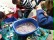 Bastelaktion: Eltern und Kinder befüllen Flaschen mit Perlen und Glitzerwasser aus einer blauen Wanne.