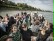 Viele Personen sitzen auf dem Oberdeck eines Ausflugschiffes auf dem Rhein.
