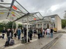 Viele Kinder und Erwachsene unter dem Dach auf dem Schulhof.