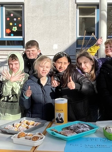 Kinder verkaufen Kuchen.
