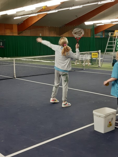 Ein Mädchen spielt Tennis.