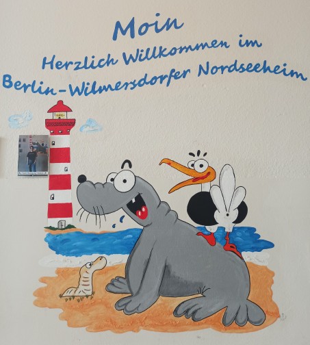 Ein Wandgemälde mit Seehund, Möwe und Leuchtturm.