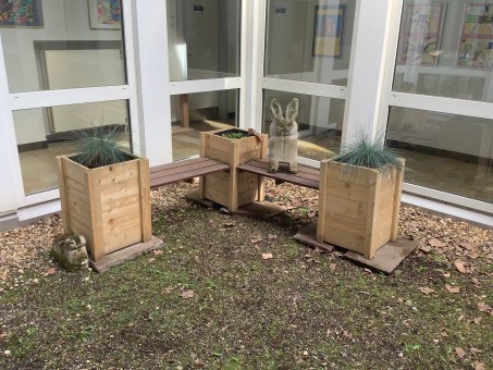 Sitzbank aus Holz mit integrierten Pflanzkästen.