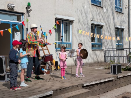Der Clown mit einigen Kindern auf der Bühne.