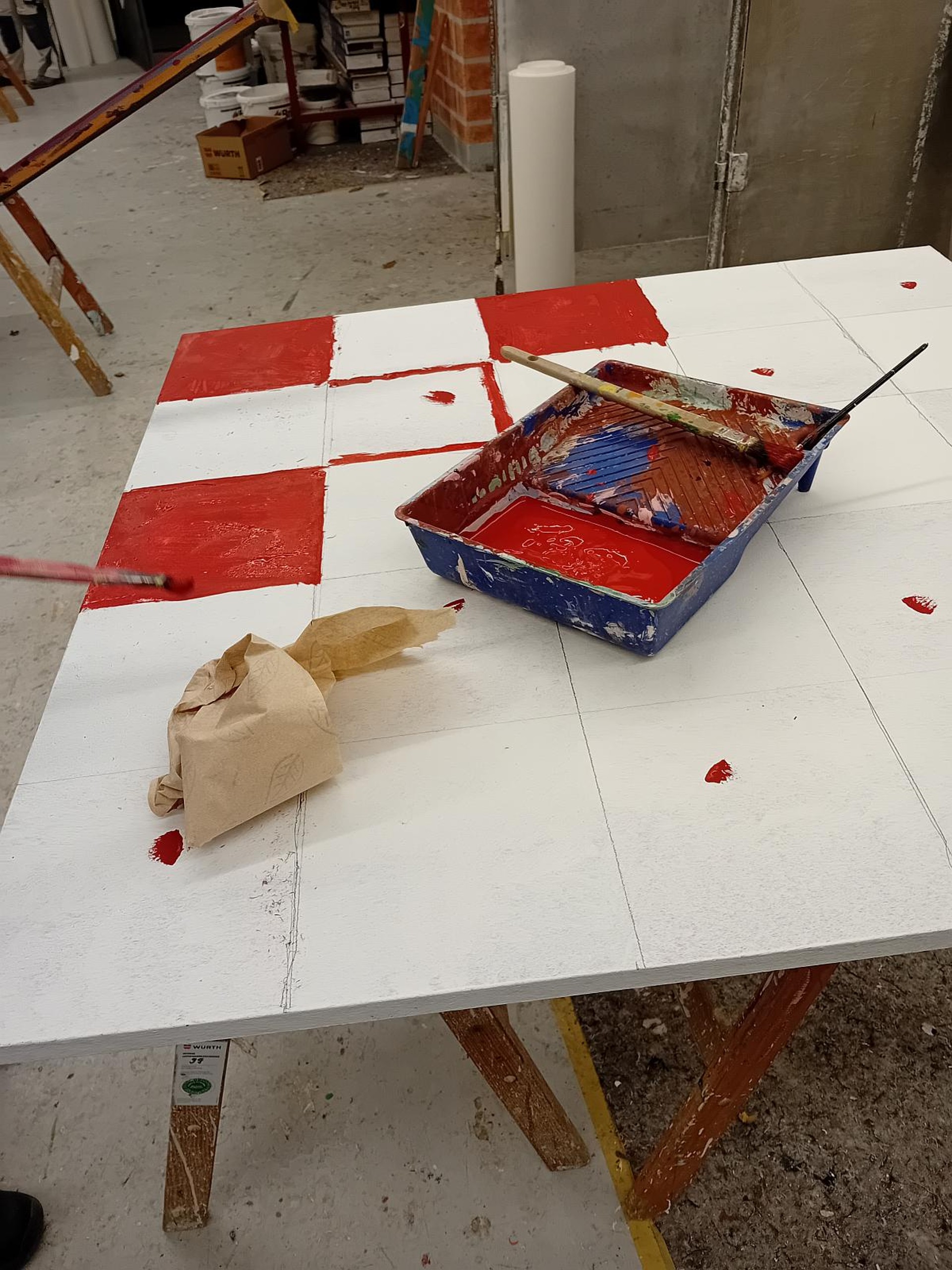 Eine große quadratische Platte ist in Quadrate unterteilt. Einige sind schon rot ausgemalt.