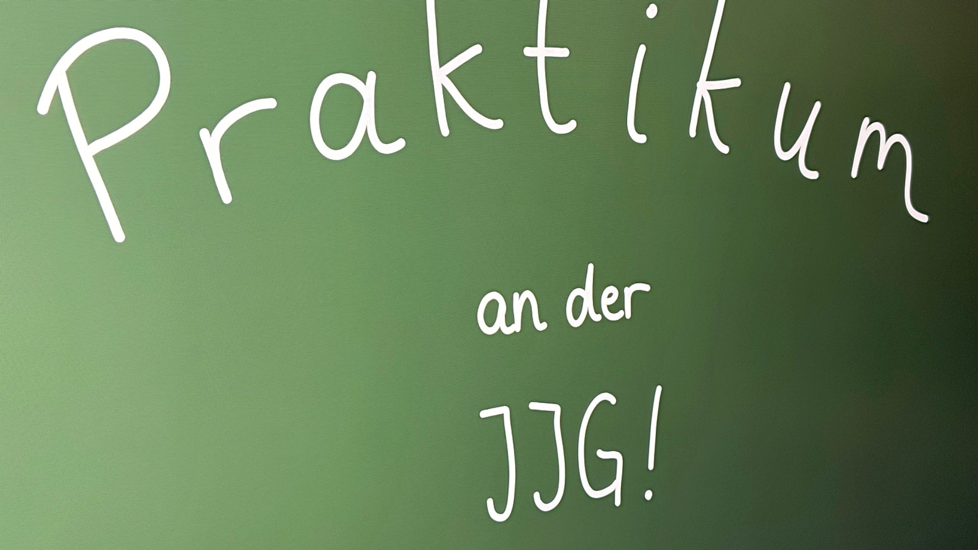 Auf einer grünen Tafel steht in weißer Schrift "Praktikum an der JJG!"