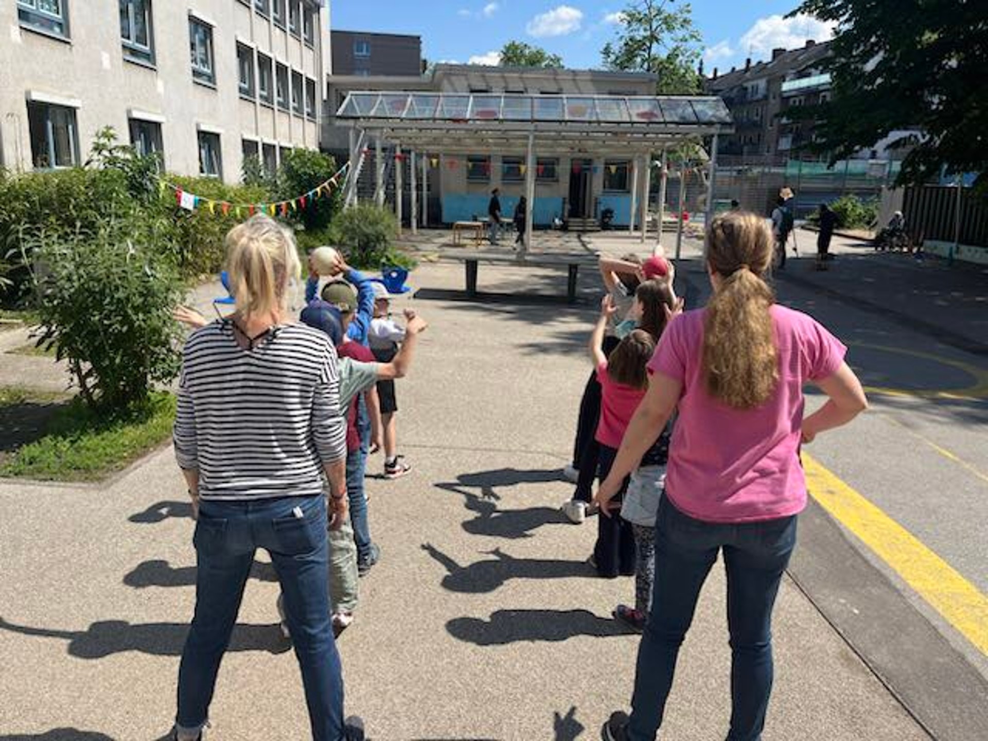 Kinder und Erwachsene stellen sich in zwei Reihen hintereinander für einen Staffellauf auf.