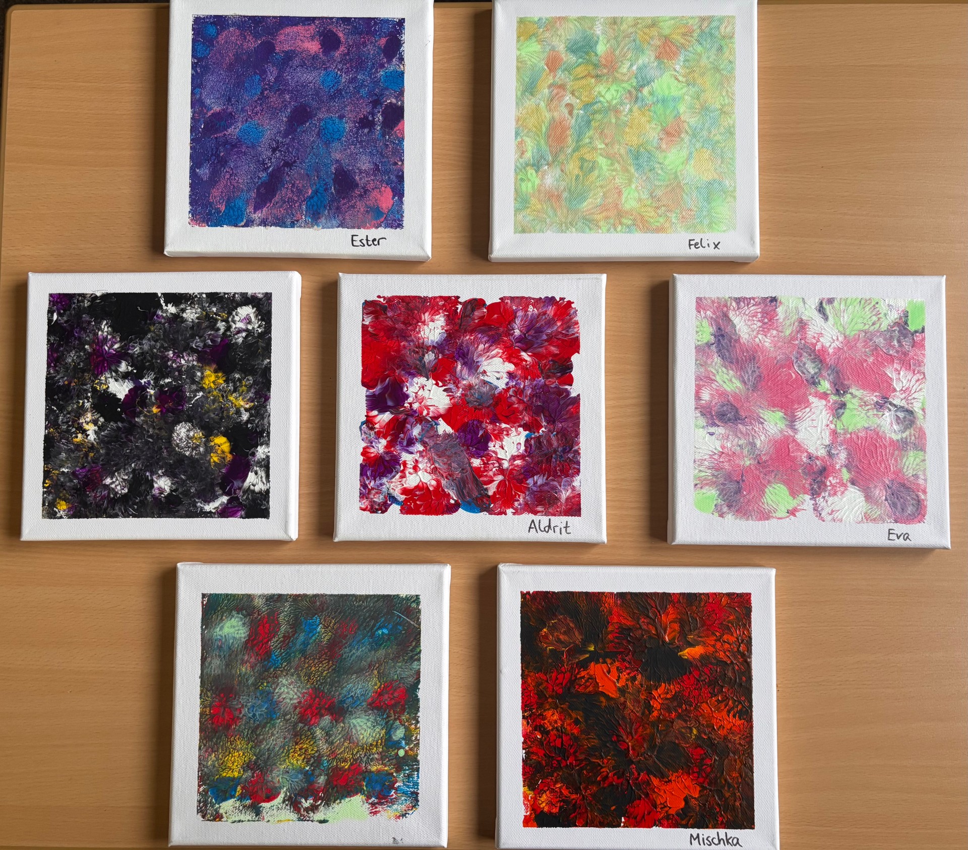 Foto mehrerer quadratischer Leinwände, die mit bunten Farben bedruckt sind.