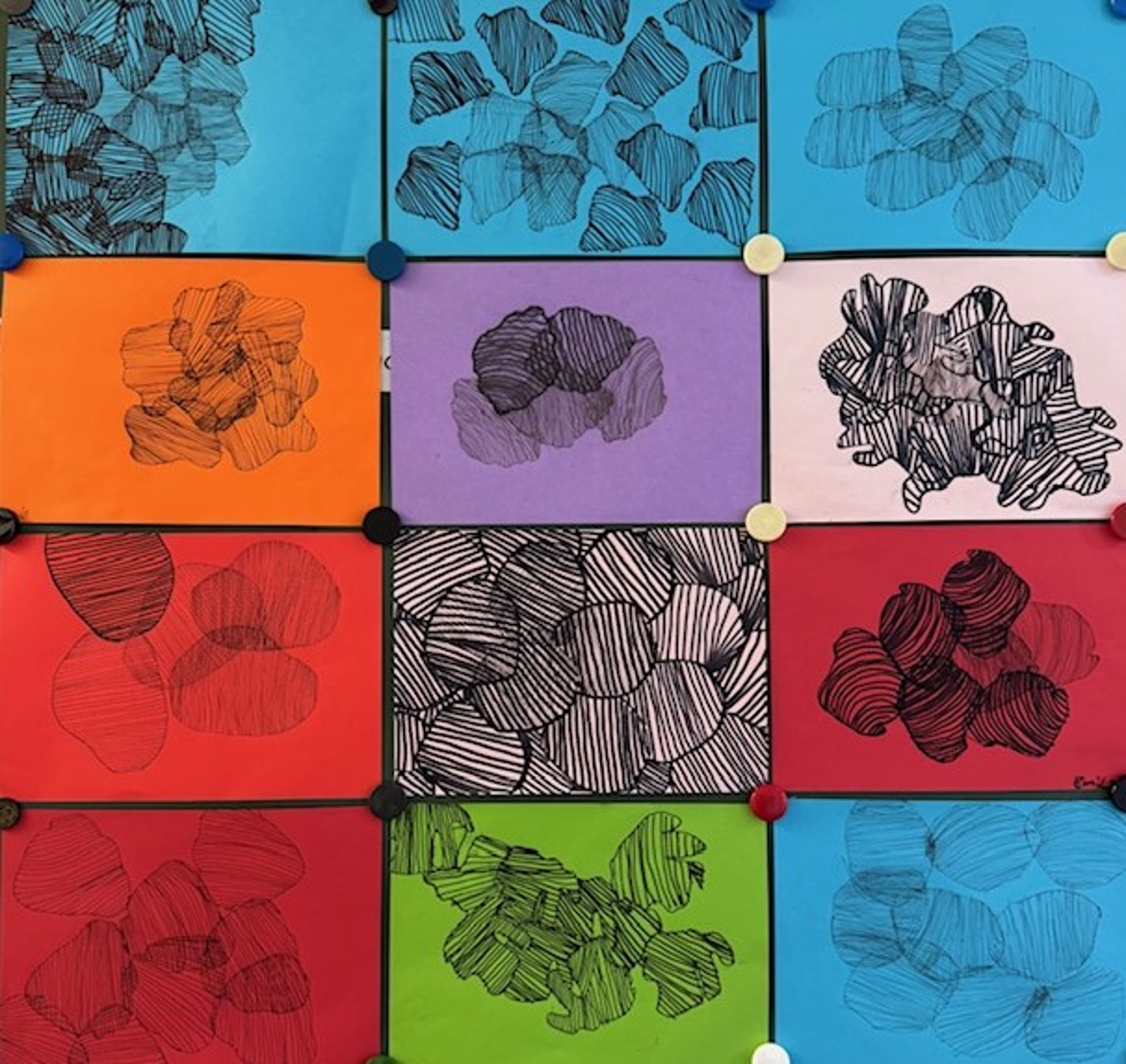 12 verschiedenfarbige Din-A4-Blätter mit schwarzen grafischen Mustern.