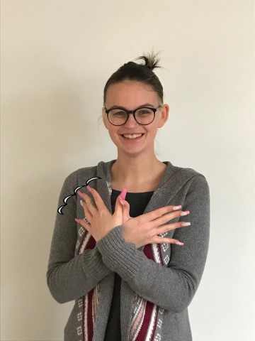 Porträtfoto Frau Pourrier. Zusammengebundenes dunkles Haar, helle Haut, schwarze, eckige Brille. 