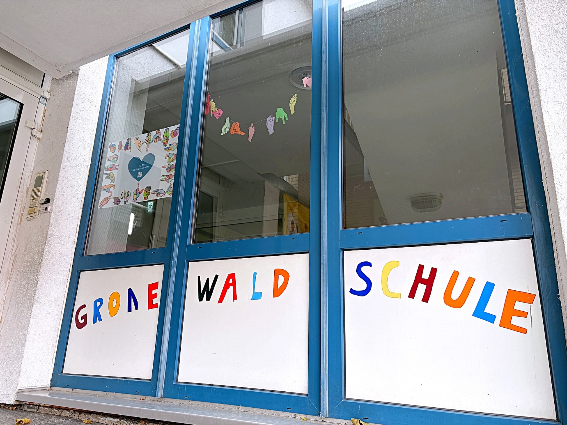 Drei Fenster im Eingangsbereich der Primarstufe: bemalt mit Herzen und dem bunten Schriftzug "Gronewaldschule"