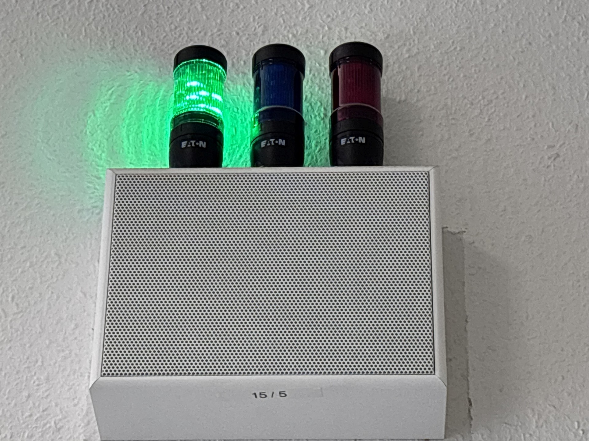 Auf einem Lautsprecher stehen drei farbige Lampen, grün, blau und rot. Grün leuchtet.